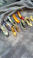 Group shot of all nine miniature shoes on grey fabric