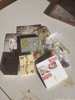 Group shot of notebooks, card packs, art book and glass tokens