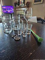 All items arranged: 2 beer steins, 4 shot glasses, wine glass, opener, muddler