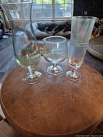 Three Pat O'Brien's hurricane glasses on round surface