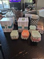 Overview of lot with two boxed plug-in warmers, three tabletop warmers, extra sleeve and wax bars