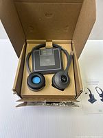 Photo showing opened packaging with a Cisco wireless headset and base unit inside the cardboard box.