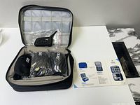 EJEAS headset units and accessories inside carrying case with lid pockets.