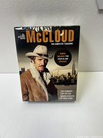 Front of McCloud DVD box set showing the main character and New York City skyline, sealed in plastic.