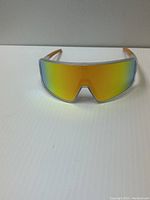 Front view of Neven ski glasses with yellow-orange mirrored lens, showing frame and lens shape.