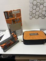 Ridgid R3101 jigsaw with carrying case and original box on white surface.