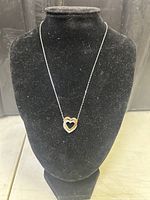 Full view of the necklace on display stand showing the pendant and chain length
