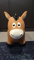 Front view of the brown horse-shaped Animal Hopper toy with large eyes and black mane.