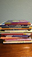 Photo showing a stack of 17 used children's books with visible titles on their spines.
