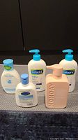 Five unused personal care bottles including Cetaphil Baby products and one Monday body wash, all in new condition.