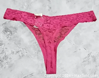 Front view of pink lace thong underwear showing floral lace pattern and thong style cut.