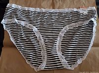 Front view of Jenni women's hipster underwear size 3XL with black and white horizontal stripes and white lace trim around waistband and legs, tag attached showing brand Jenni.