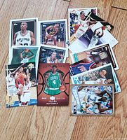 Photo showing a spread of 16 basketball trading cards from various teams and players in good condition.