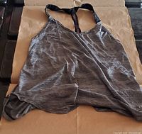 Front view of heather gray Nike Dri Fit halter workout top laid flat to show neckline, straps, and fabric texture.