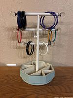 Full view of all 10 assorted bangle bracelets displayed on a white stand with some bracelets in close proximity to each other showing colors and styles.