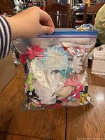 Bag of various flower hair clips in different colors and styles shown from front side.