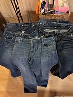 Seven pairs of size 16 women's jeans laid out showing front waistbands and pockets.