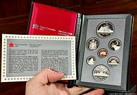 Black box with red satin interior holding 7 proof coins and certificate of authenticity.