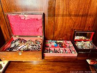 Three jewelry boxes on wooden surface showing overall lot