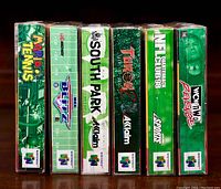 Photo showing side view of six Nintendo 64 game boxes including Mario Tennis, Blitz, South Park, Turok, NFL, WCW with their logos and spine details.