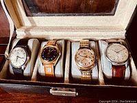 Four vintage men's wristwatches in velvet-lined display case