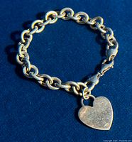 Full view of the chunky sterling silver chain bracelet with heart pendant