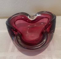 Front angle showing the thick clear and violet layered glass and the general shape of the ashtray with three cigarette rests.