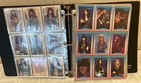 Photo of Brockum rock cards in a black binder with plastic protective sheets. Cards show front images of various rock band members.