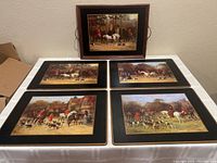 Photo showing one wooden serving tray with fox hunting scene and four coordinated cork-backed placemats with similar fox hunting designs, all placed on a table.