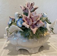 Front and side view of vintage Capodimonte porcelain bowl showing detailed hand-sculpted roses, bluebells, leaves, and two white doves.