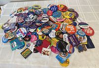Large pile of assorted pinback buttons of various sizes and themes, including political and advertising.
