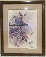 Full view of framed art print showing bird on branch with leaves, inside wood frame and cream matting