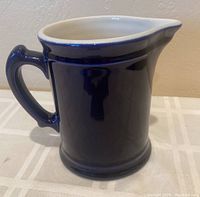 Front view of cobalt blue ceramic pitcher showing handle and spout
