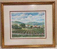 Framed art print showing overall view of farm landscape art with gold frame and white/brown matting.