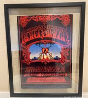 Frontal photo showing entire framed rock concert poster with red ornate lettering and psychedelic artwork.