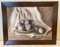 Framed oil painting showing a still life with garlic bulbs on a cloth background and signature visible.