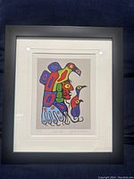 Front view of framed colorful indigenous art print by Norval Morrisseau titled 'Raggs'.