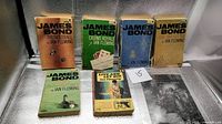 Front covers of seven paperbacks displayed
