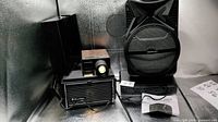 Front view of Bell & Howell projector, bookshelf speaker, PA speaker and receiver