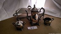 Full view of coffee pot, sugar bowl, creamer, platter and stand