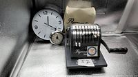 Front view of Paymaster check writer, wall clock, desk clock, and dust cover