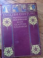 Front cover of the book with title, author, and decorative elements in maroon, gold, and blue colors.