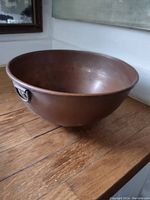 Photo of large vintage copper mixing bowl showing interior and ring handle on side.