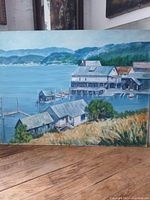 Full view of the oil painting showing a coastal scene with buildings and water.