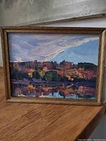 Full front view of the small oil painting in frame showing colorful landscape and signature