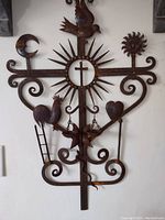 Full frontal view of iron roof crest cross mounted on wall