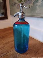 Full view of the blue glass spritzer bottle with metal top and label