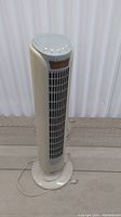 Full front view of Aloha Breeze tower fan showing vertical grille and base with attached power cord.