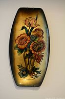 Close-up view of the antique tempered glass wall art showing detailed floral painting and curved rectangular shape.