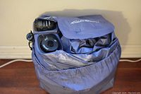 Air bed mattress rolled and packed inside branded Eddie Bauer carrying bag, showing the built-in pump unit and inflation valve.